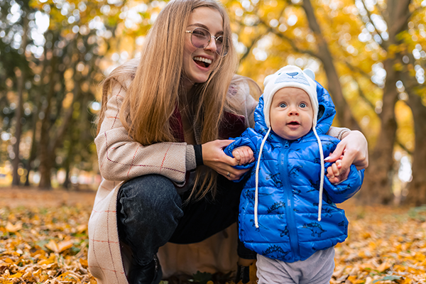 Mother helping child to stand for the first time